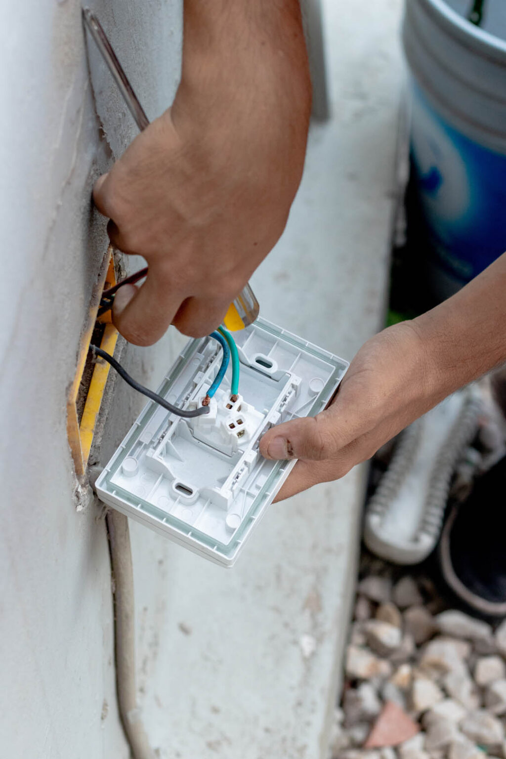 Person installing a new light switch or power outlet with a scre